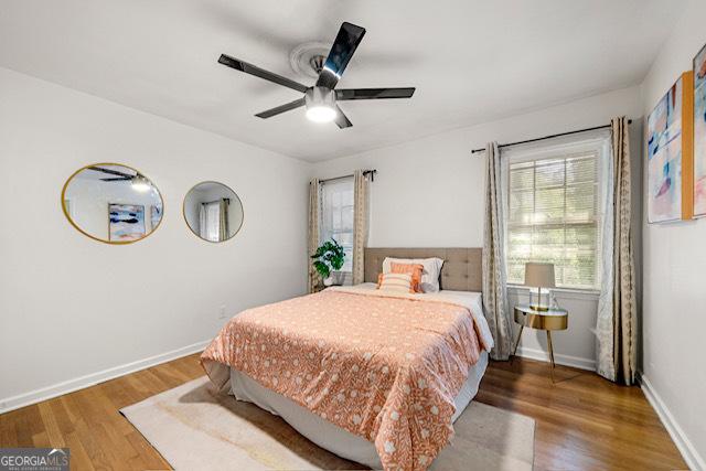 bedroom featuring baseboards, ceiling fan, and wood finished floors