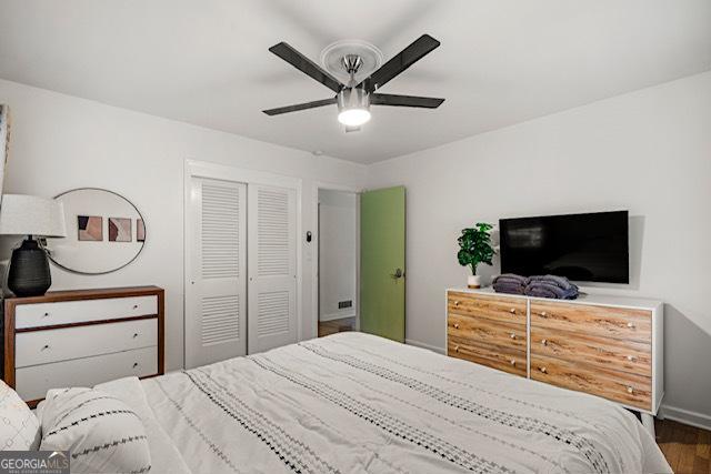 bedroom with a closet, wood finished floors, and a ceiling fan