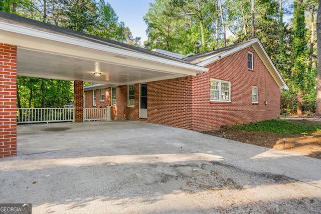 view of front of property with a carport, brick siding, and concrete driveway