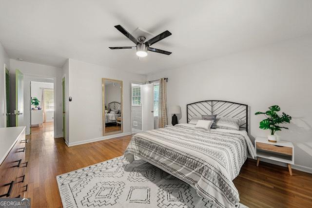 bedroom featuring baseboards, multiple windows, ceiling fan, and wood finished floors