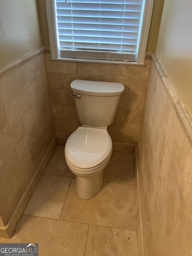 4 Baldwin Pl SE, Moultrie, GA 31788 - bathroom featuring tile walls, wainscoting, toilet, and tile patterned floors