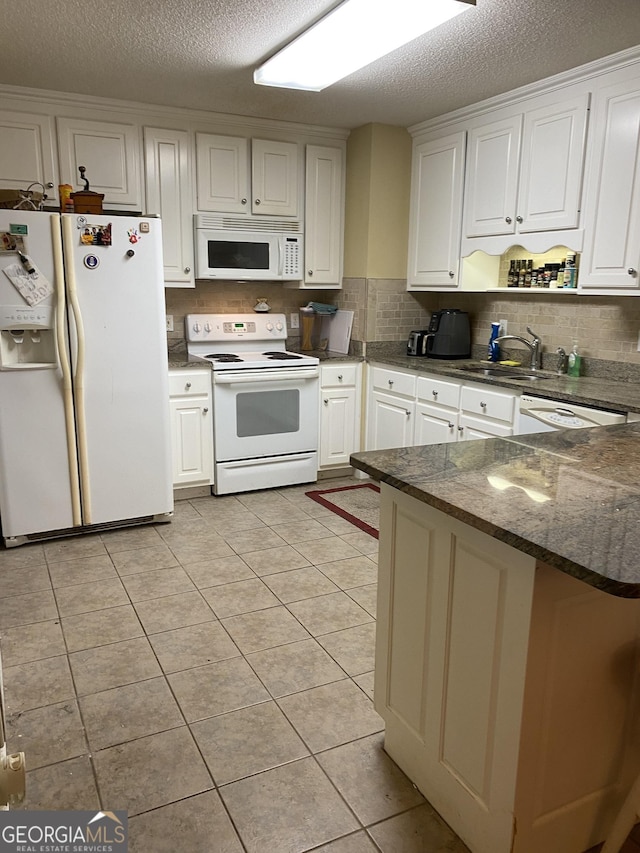 4 Baldwin Pl SE, Moultrie, GA 31788 - kitchen featuring white appliances, a sink, a textured ceiling, white cabinetry, and a peninsula