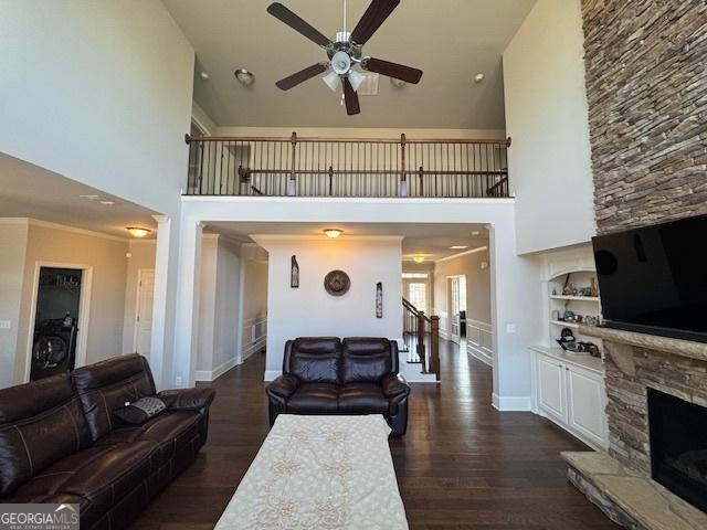 5530 Lacebark Pine Ct, Cumming, GA 30040 - living area with high vaulted ceiling, a ceiling fan, dark wood-type flooring, a stone fireplace, and stairway