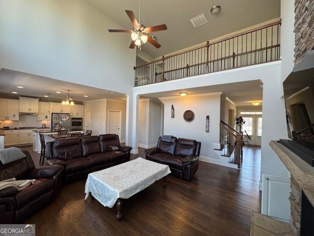 5530 Lacebark Pine Ct, Cumming, GA 30040 - living area featuring high vaulted ceiling, dark wood finished floors, a ceiling fan, stairway, and recessed lighting