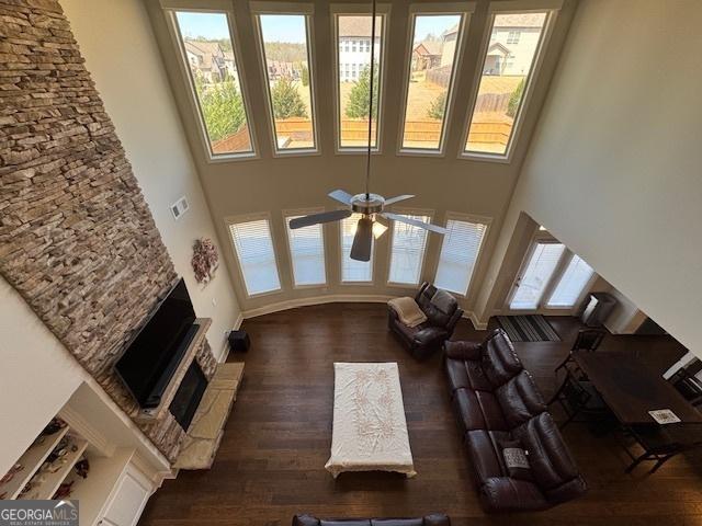 5530 Lacebark Pine Ct, Cumming, GA 30040 - living room with a high ceiling, ceiling fan, a fireplace with raised hearth, and wood finished floors