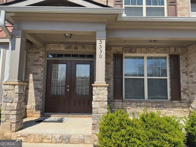 5530 Lacebark Pine Ct, Cumming, GA 30040 - entrance to property with french doors, covered porch, brick siding, and stone siding