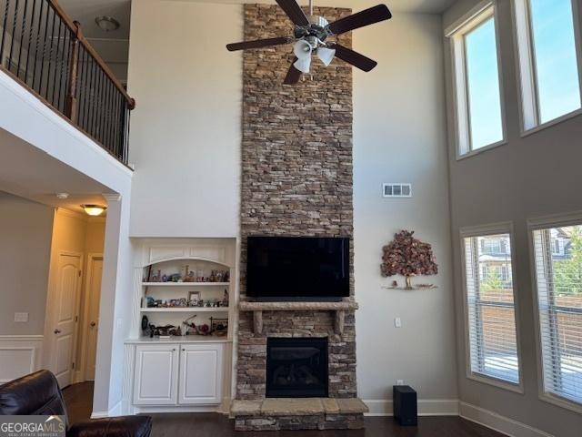 5530 Lacebark Pine Ct, Cumming, GA 30040 - living area with a high ceiling, a stone fireplace, ceiling fan, wood finished floors, and built in features