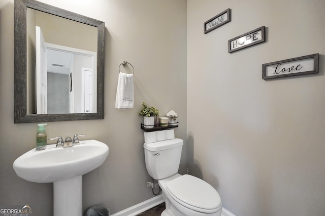 bathroom featuring baseboards, toilet, and visible vents
