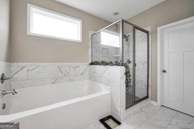 full bathroom featuring a stall shower, a bath, and marble finish floor