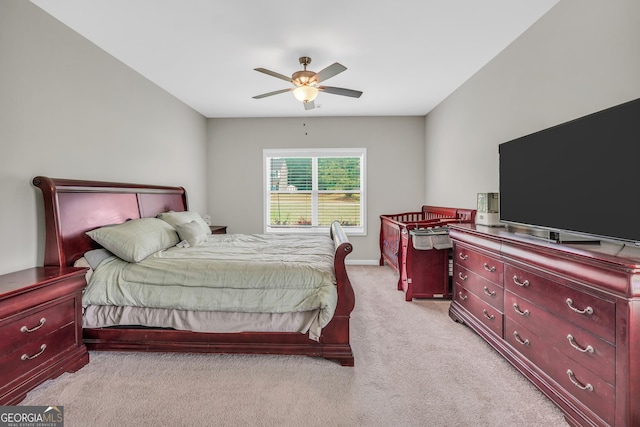 bedroom featuring light colored carpet, a ceiling fan, and baseboards