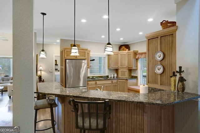 765 River Oaks Dr, Hayesville, NC 28904 - kitchen featuring a peninsula, ornamental molding, light brown cabinets, dark stone countertops, and freestanding refrigerator
