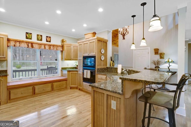 765 River Oaks Dr, Hayesville, NC 28904 - kitchen with a notable chandelier, a kitchen breakfast bar, a peninsula, light wood-style flooring, and decorative light fixtures