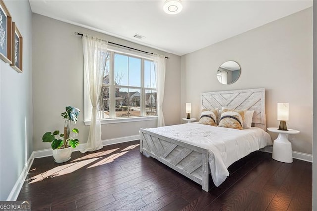 bedroom with baseboards, dark wood-style flooring, and visible vents