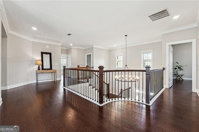 hallway featuring hardwood / wood-style floors, visible vents, a healthy amount of sunlight, and an upstairs landing