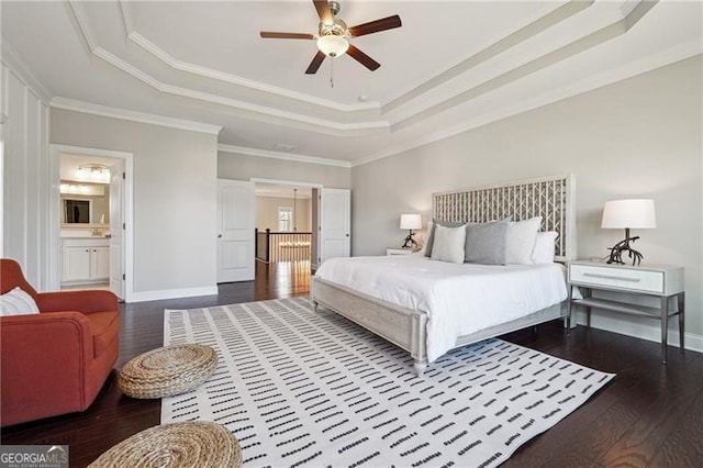 bedroom featuring crown molding, baseboards, a raised ceiling, and dark wood finished floors