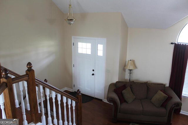 foyer entrance featuring baseboards, lofted ceiling, and wood finished floors