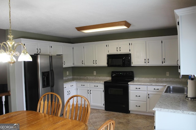kitchen featuring white cabinetry, light countertops, hanging light fixtures, a sink, and black appliances