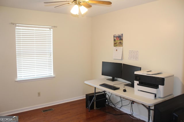 home office featuring dark wood finished floors, baseboards, visible vents, and ceiling fan