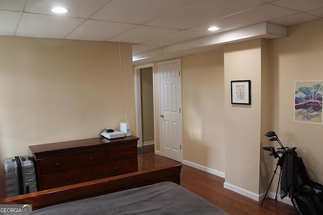 bedroom featuring baseboards, wood finished floors, recessed lighting, and a drop ceiling