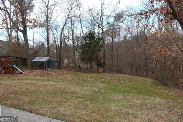 view of yard with a storage shed, an outdoor structure, and a playground