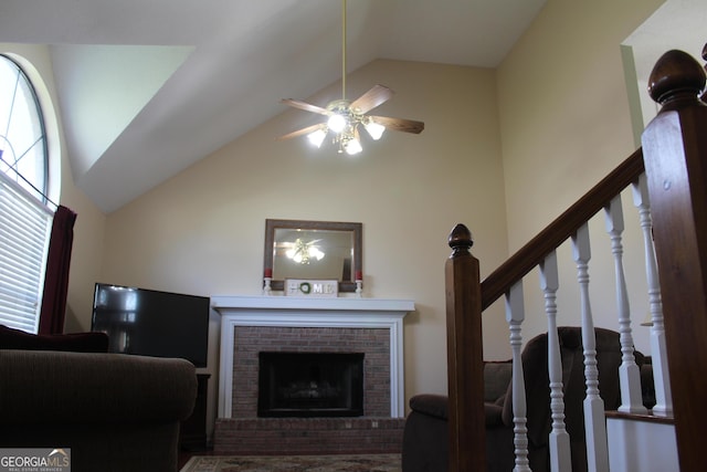 living room featuring a brick fireplace, high vaulted ceiling, stairs, and a ceiling fan