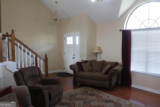 living area featuring baseboards, high vaulted ceiling, and wood finished floors