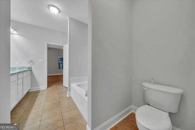 full bathroom with vanity, baseboards, a textured ceiling, tile patterned floors, and a bath