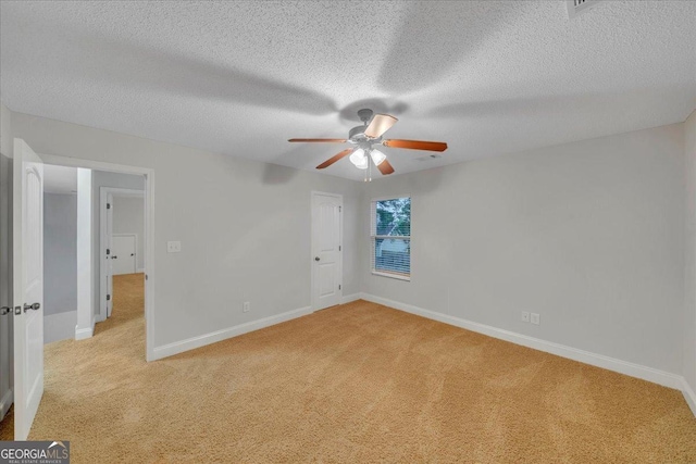 unfurnished bedroom with baseboards, light colored carpet, and a textured ceiling