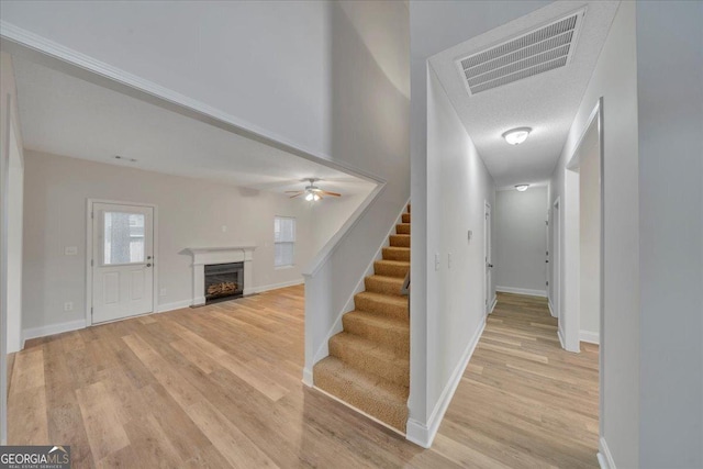 stairway with baseboards, a fireplace, visible vents, and wood finished floors