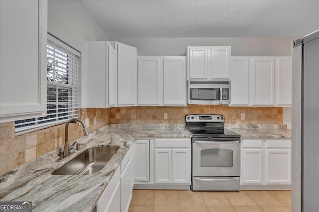 kitchen featuring white cabinetry, a sink, appliances with stainless steel finishes, and decorative backsplash
