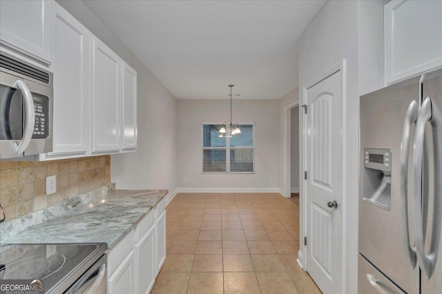 kitchen featuring a notable chandelier, backsplash, white cabinetry, and stainless steel appliances