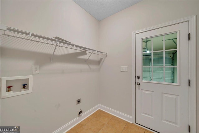 washroom with light tile patterned floors, hookup for a washing machine, baseboards, electric dryer hookup, and laundry area