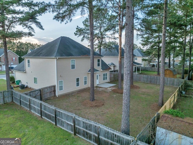 view of property exterior with a fenced backyard, central AC, and a lawn