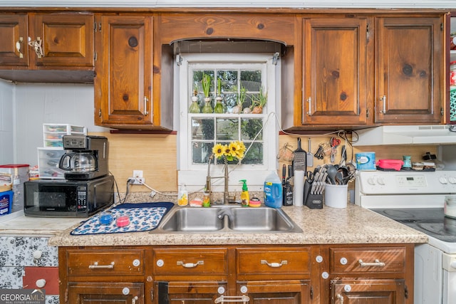 403 Spurgeon St, Waycross, GA 31501 - kitchen featuring light countertops, black microwave, white range with electric stovetop, brown cabinets, and decorative backsplash