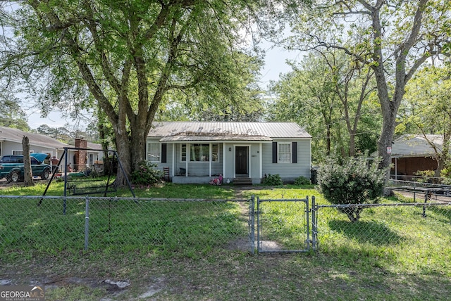 403 Spurgeon St, Waycross, GA 31501 - view of front of home with metal roof, a fenced front yard, a front lawn, and a gate