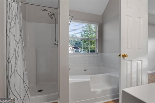 4625 Thermal Ct, Douglasville, GA 30135 - bathroom featuring lofted ceiling, a shower stall, wood finished floors, and a bath