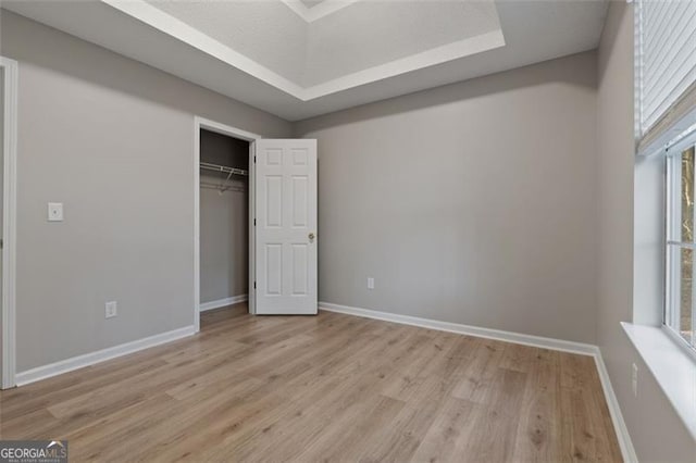 4625 Thermal Ct, Douglasville, GA 30135 - unfurnished bedroom featuring baseboards, a closet, light wood finished floors, and a raised ceiling