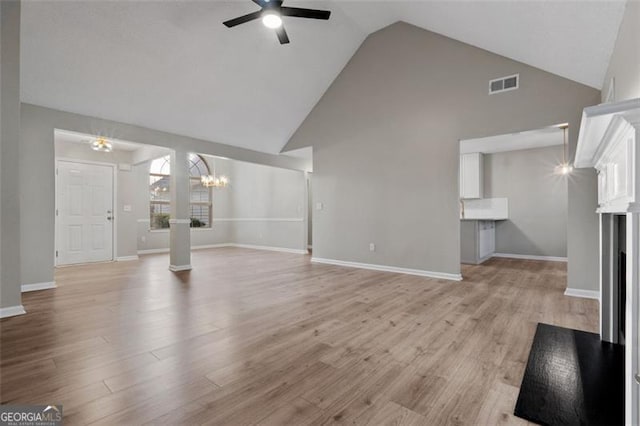 4625 Thermal Ct, Douglasville, GA 30135 - unfurnished living room featuring visible vents, baseboards, high vaulted ceiling, light wood finished floors, and ceiling fan with notable chandelier