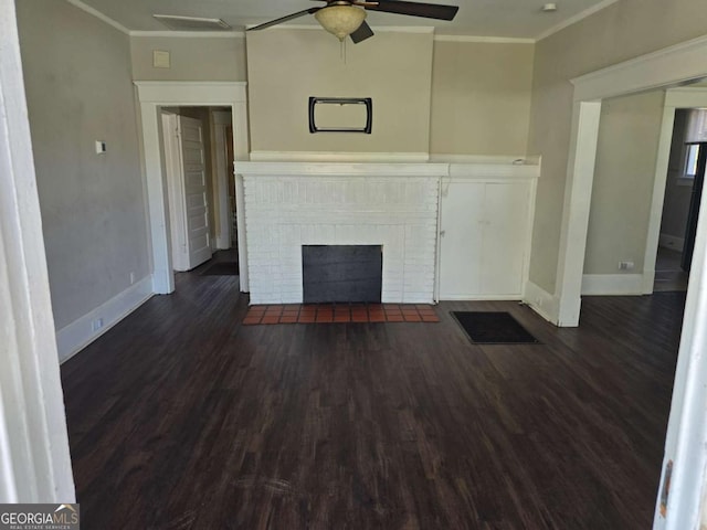 unfurnished living room featuring a brick fireplace, crown molding, dark wood-type flooring, and a ceiling fan