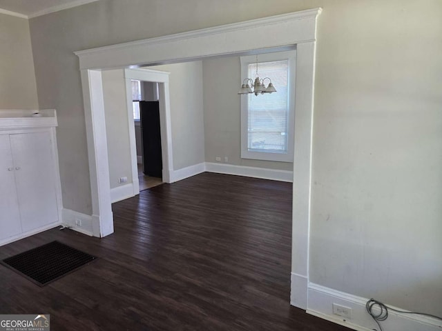 interior space featuring baseboards, ornamental molding, an inviting chandelier, and dark wood finished floors