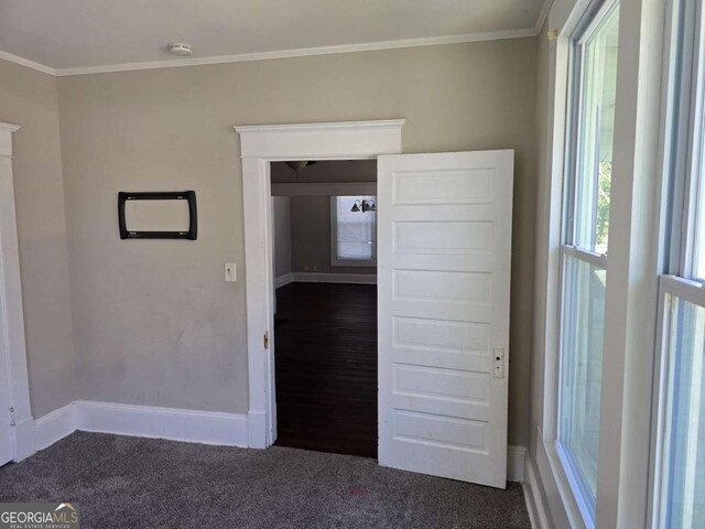 unfurnished room featuring carpet, crown molding, and baseboards