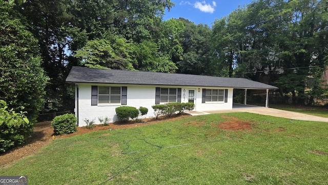 ranch-style home featuring concrete driveway, an attached carport, a front lawn, and brick siding