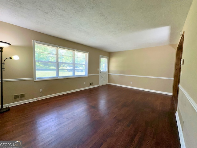 unfurnished room featuring wood finished floors, a textured ceiling, and baseboards