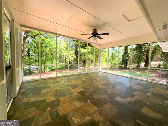 unfurnished sunroom featuring ceiling fan