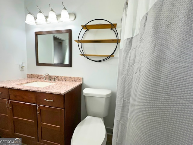 bathroom featuring toilet, vanity, and curtained shower