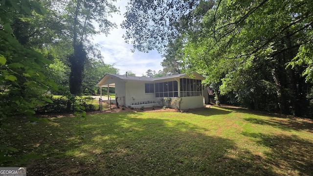 view of grassy yard featuring a sunroom