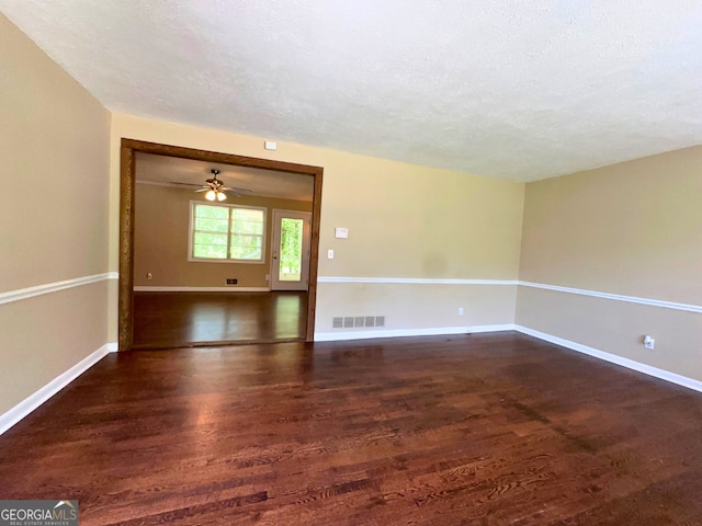 empty room with wood finished floors, baseboards, a textured ceiling, and a ceiling fan