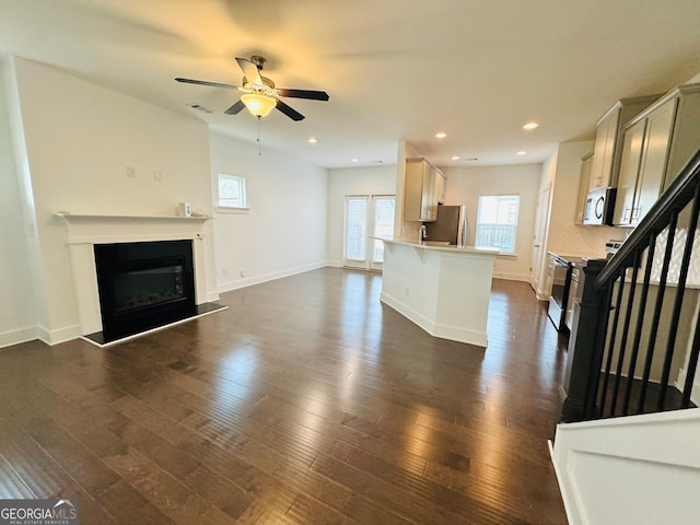 124 Auburn Run Ln, Auburn, GA 30011 - unfurnished living room with a ceiling fan, dark wood-type flooring, a glass covered fireplace, baseboards, and recessed lighting