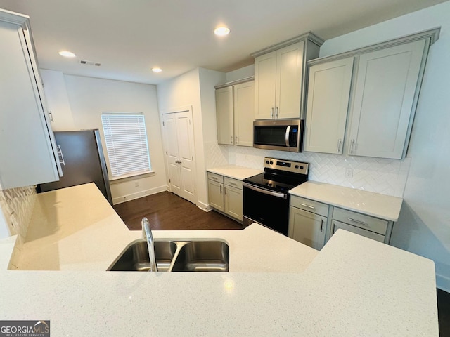 124 Auburn Run Ln, Auburn, GA 30011 - kitchen featuring appliances with stainless steel finishes, a sink, tasteful backsplash, light countertops, and gray cabinets