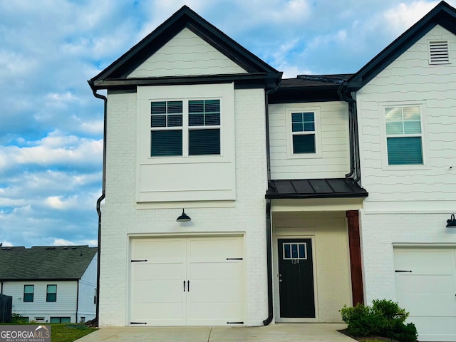124 Auburn Run Ln, Auburn, GA 30011 - view of front of house with brick siding, a garage, a standing seam roof, and driveway